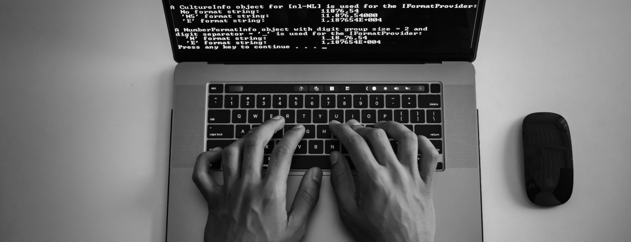 Mãos digitando em um notebook durante uma sessão prática com IA